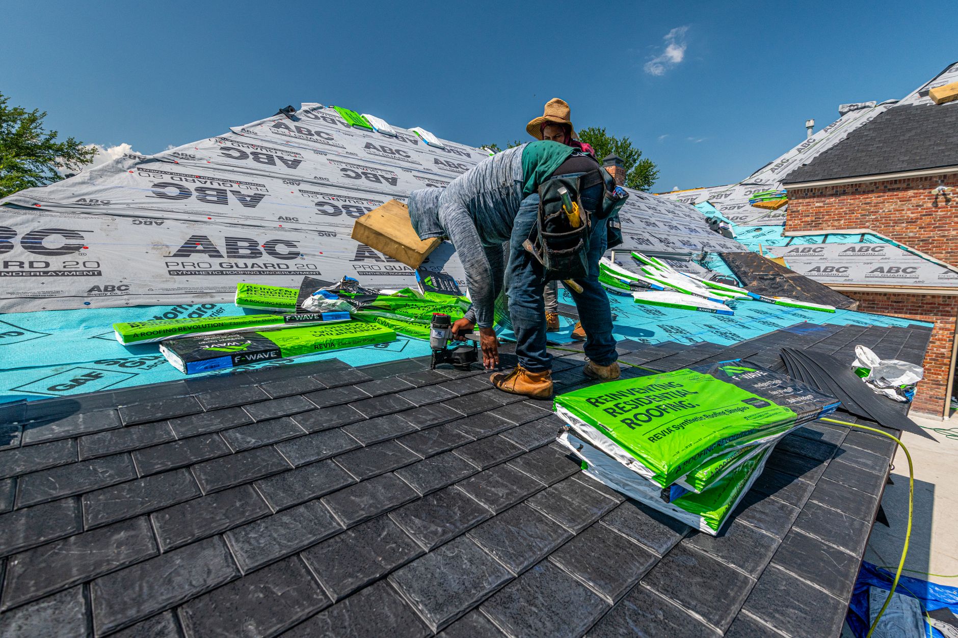 Professional roofing contractors installing a new metal roof on a residential home in New England
